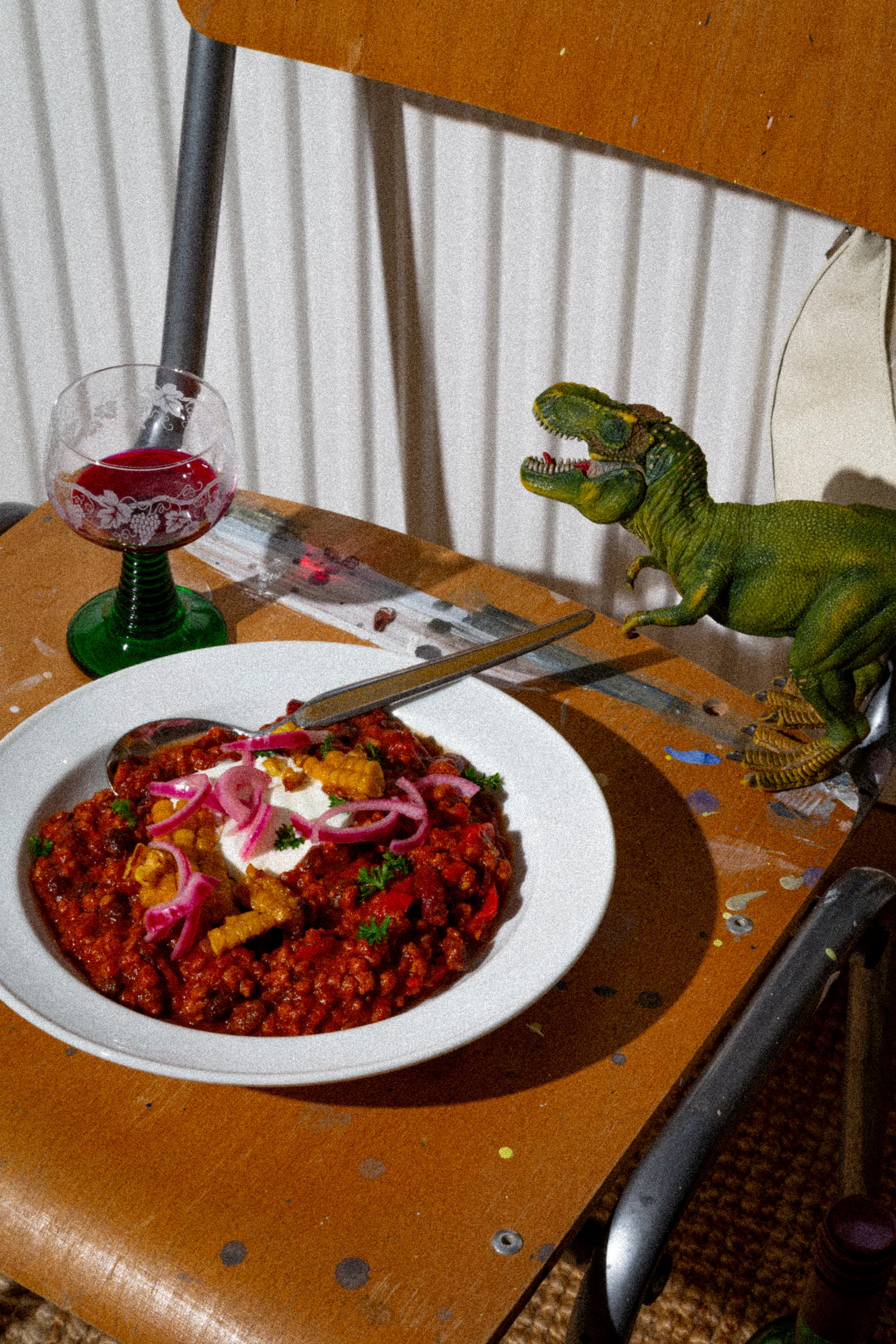 Chili Con Espresso mit T-Rex-Spielfigur auf Stuhl