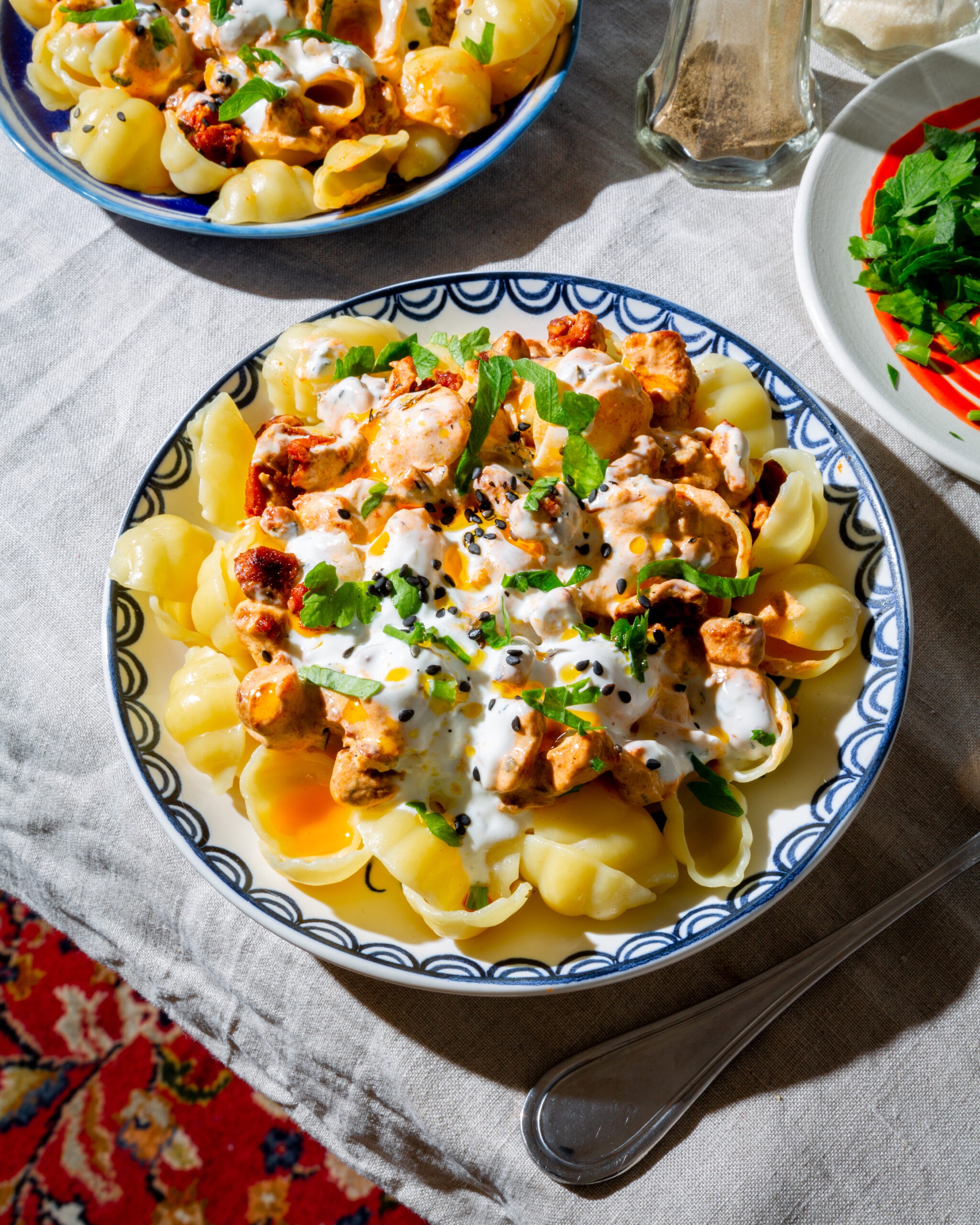 Pasta Manti Style serviert auf floralen Tellern auf einem Tisch mit Tischdecke.